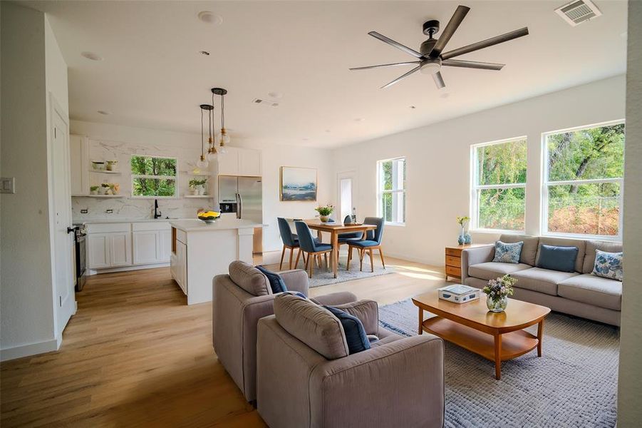 Living room with light wood-type flooring, sink, and ceiling fan