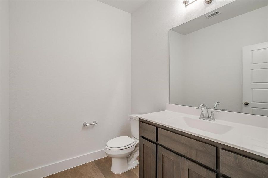 Bathroom featuring wood-type flooring, toilet, and large vanity