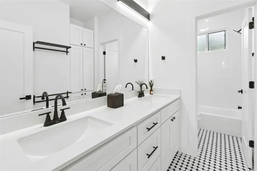 Full bathroom featuring double vanity and shower / bath combination Full bathroom featuring double vanity and shower / bath combination