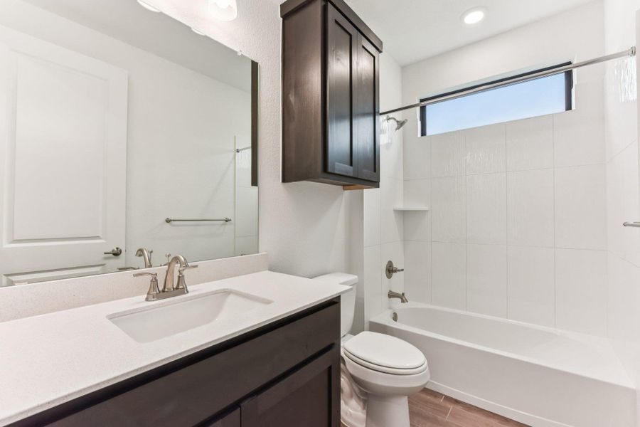 Bathroom featuring shower / bath combination, vanity, and wood finish floors Bathroom featuring shower / bath combination, vanity, and wood finish floors