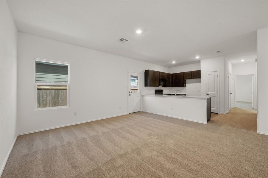 Unfurnished living room featuring light carpet and recessed lighting Unfurnished living room featuring light carpet and recessed lighting
