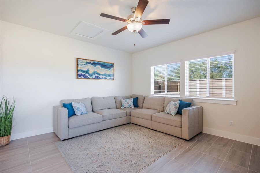 Living room featuring attic access and ceiling fan Living room featuring attic access and ceiling fan
