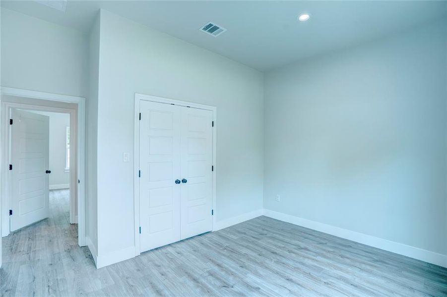 Room featuring panel doors, wood-finish flooring, and white trim