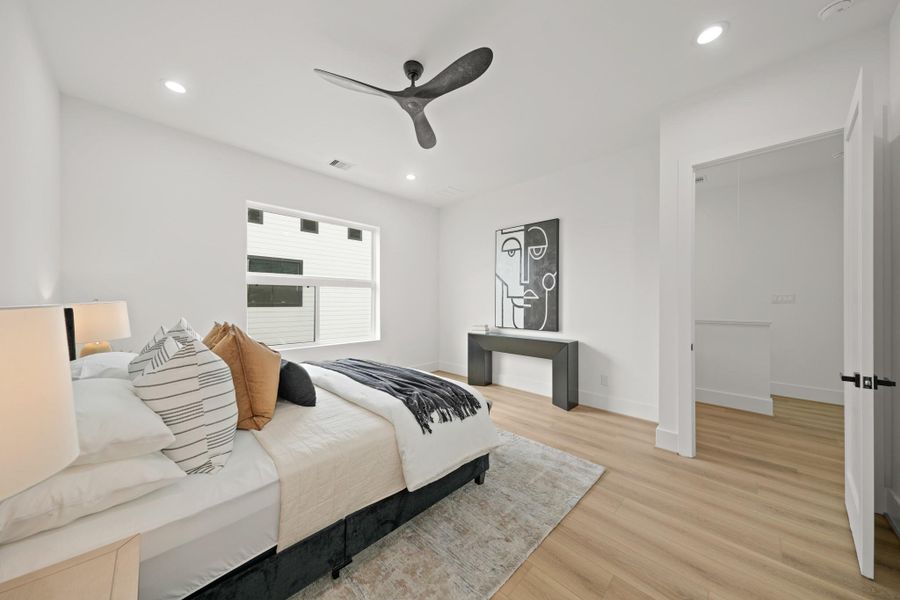 A view of the owner's bedroom with access to the hallway. A built in study nook and the utility room are located outside the owner’s suite .