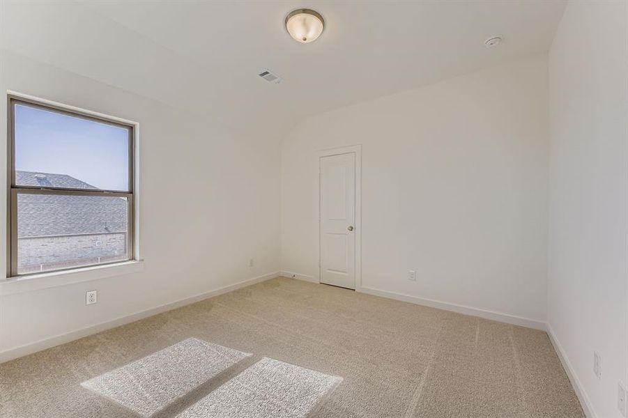 Empty room with light colored carpet and vaulted ceiling Empty room with light colored carpet and vaulted ceiling