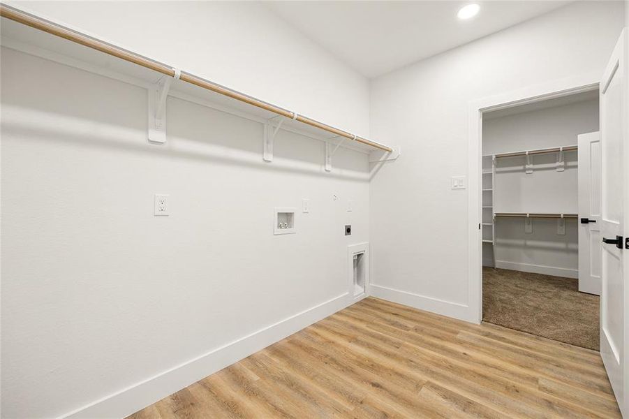 Spacious Laundry Room with Direct Access to Primary BedroomThis well-designed laundry room offers built-in shelving, hanging rods, and washer/dryer connections for ultimate convenience. Featuring stylish flooring and a functional layout, it provides direct access to the primary bedroom and walk-in closet, making laundry days effortless!