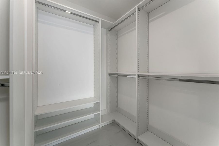 Serene primary suite offering unobstructed water views, direct terrace access, oversized walk-in closets, and floor-to-ceiling windows for a true 'mansion in the sky' feel.