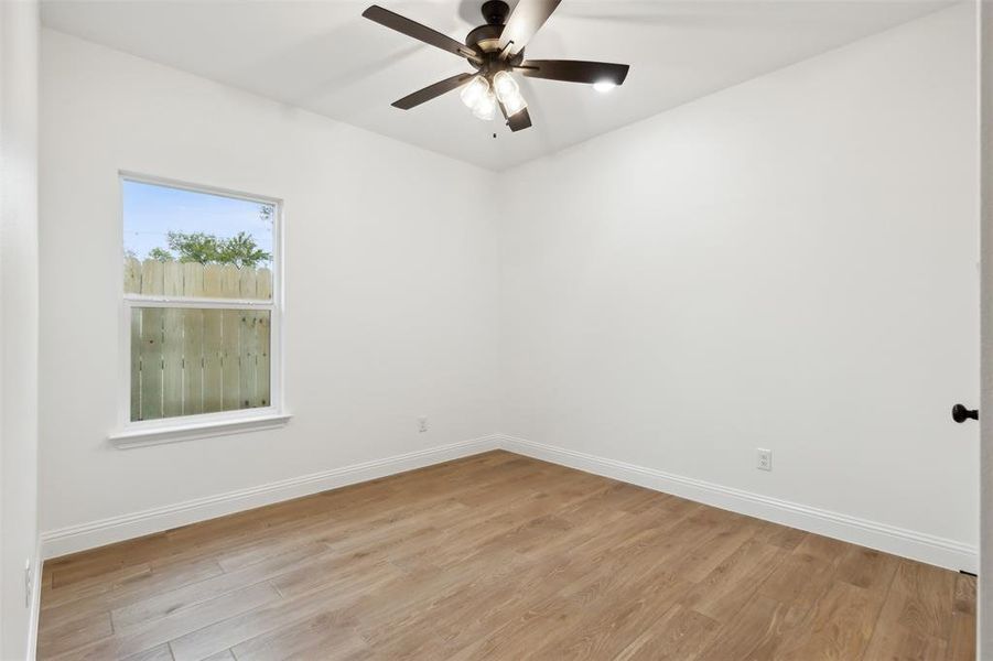 Unfurnished room with light hardwood / wood-style floors and ceiling fan