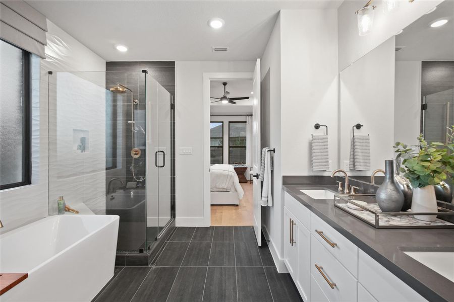 Bathroom featuring a freestanding tub, ensuite bath, double vanity, a stall shower, and recessed lighting