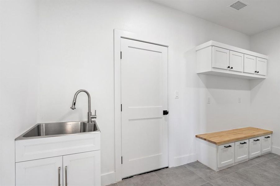 Mudroom featuring light tile patterned floors and sink