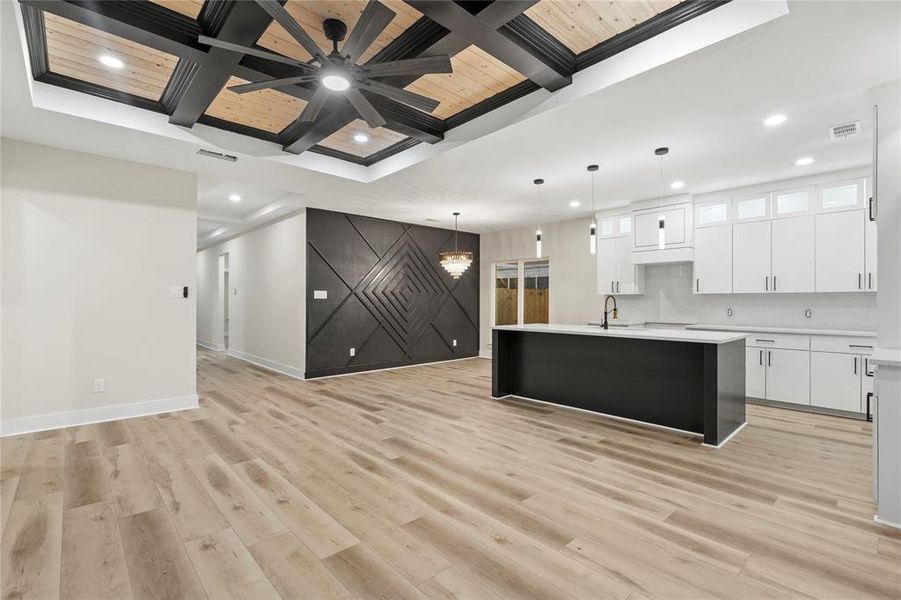 Kitchen with coffered ceiling, white cabinets, hanging light fixtures, a ceiling fan, and a wood ceiling with exposed beams