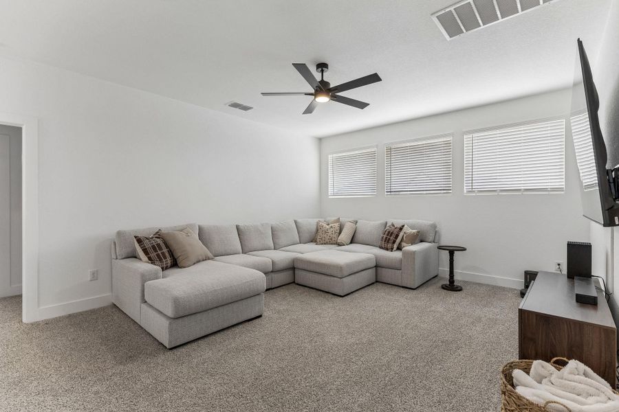Plush wall-to-wall carpeting and clean architectural lines define this comfortable upstairs media space.