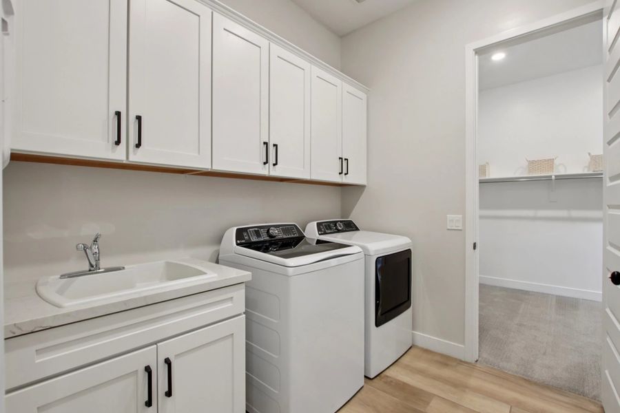 Laundry room with passthrough to primary walk in closet