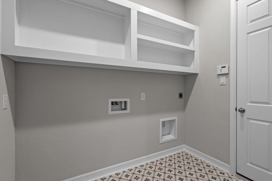 The laundry room layout is carefully planned for optimal workflow with designated areas for washing, drying, and storing.