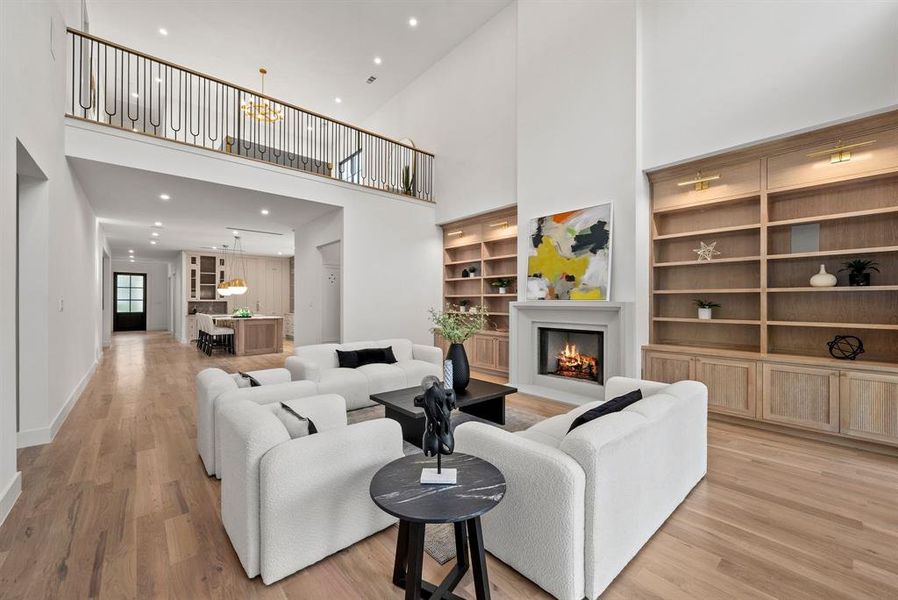 Living room featuring hardwood floors, a fireplace with a mantel, and built-in shelving