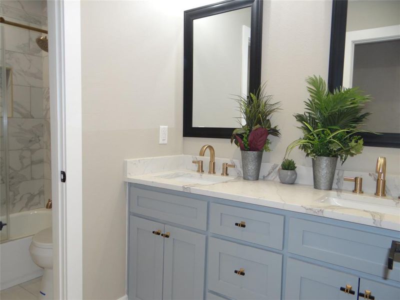 Full bathroom upstairs featuring tiled shower / bath, vanity, and toilet