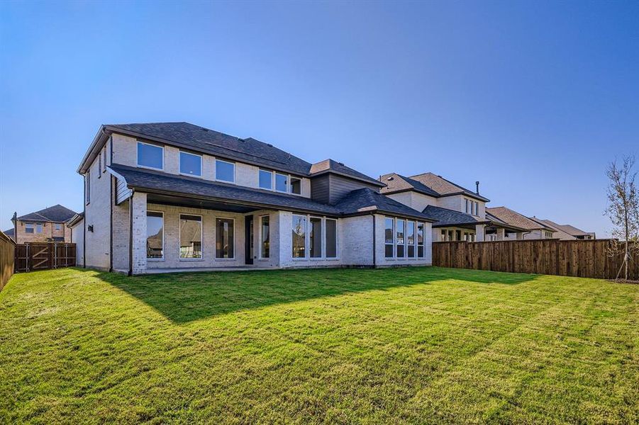 Rear view of property featuring a fenced backyard, a patio area, and brick siding