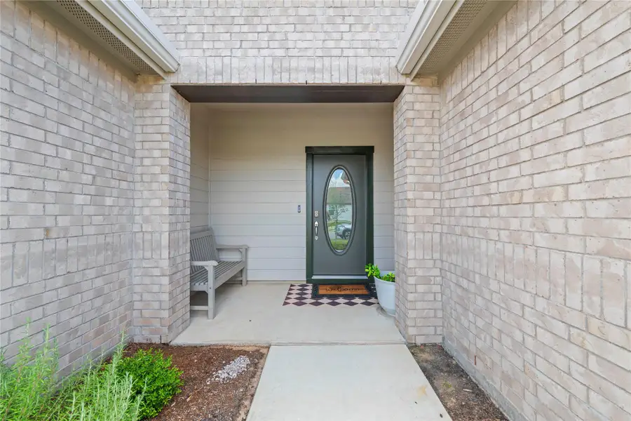A welcoming brick facade with a modern door awaits at this charming entry.