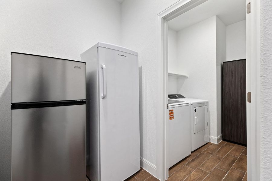 Functional utility space with washer, dryer, and additional refrigeration.
