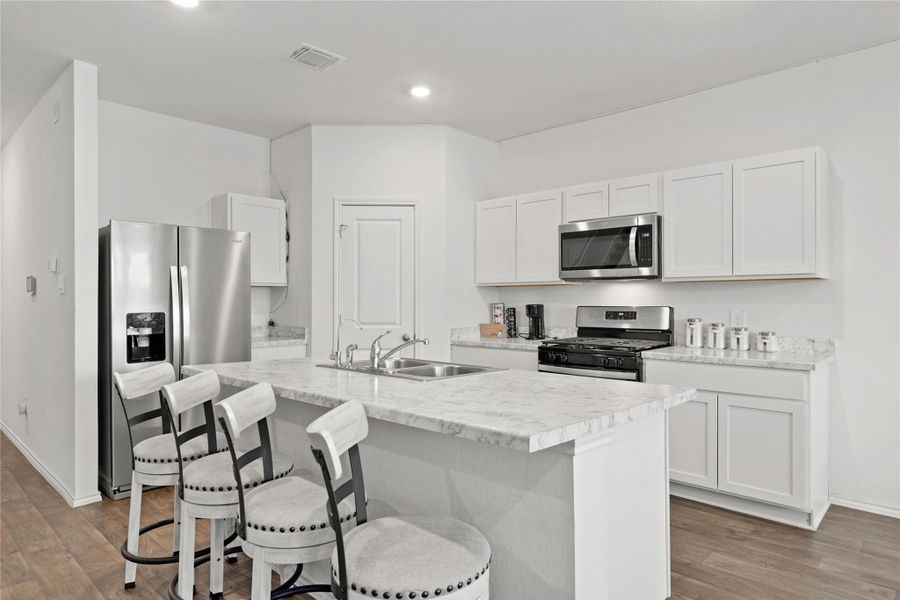 Countertop Perfection! Get up close and personal with these stunning marble-inspired countertops that offer miles of prep space and a social breakfast bar—the perfect spot for morning coffee or evening cocktails.
