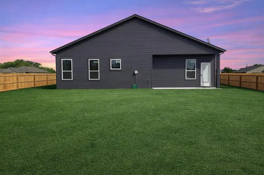 Rear view of house with a fenced backyard
