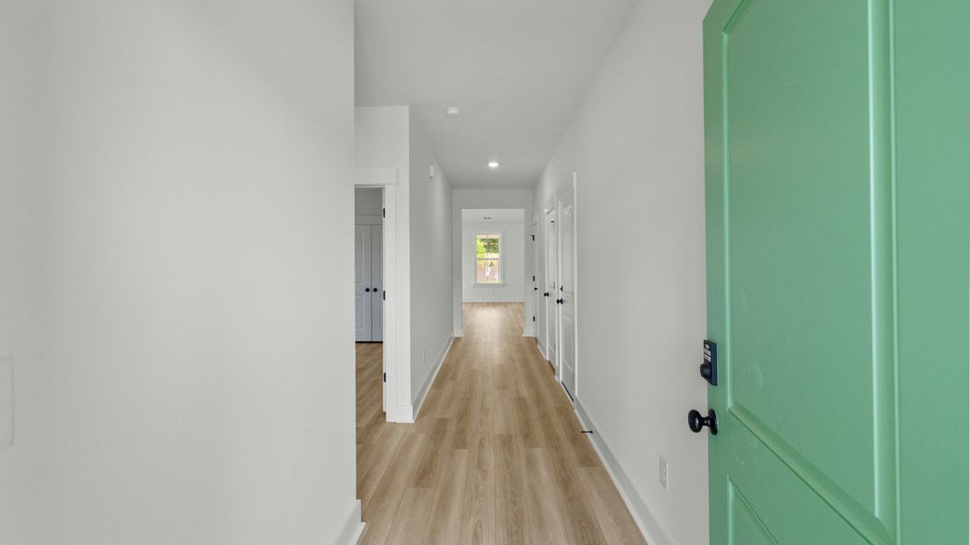 Welcoming hallway with LVP floors and Craftsman trim at Chestnut Farms by DRB Homes