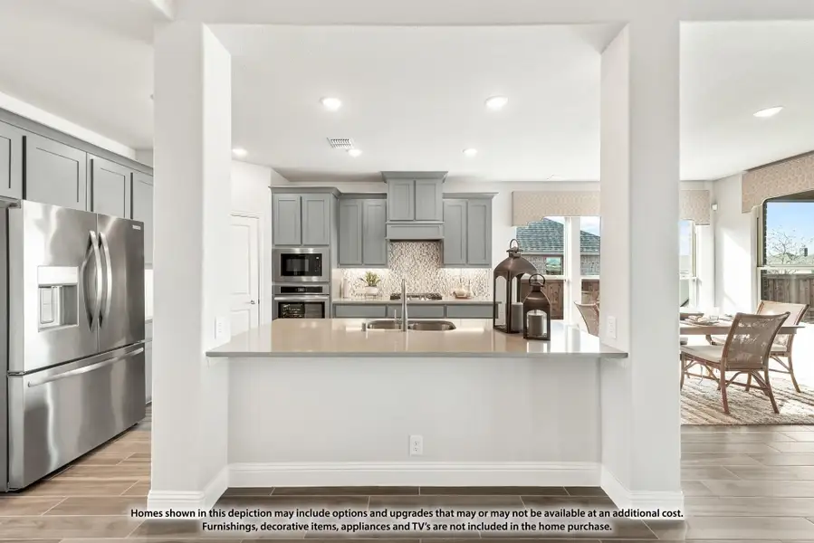 Kitchen with gray cabinets, tile backsplash, island with sink, and stainless steel appliances Kitchen with gray cabinets, tile backsplash, island with sink, and stainless steel appliances