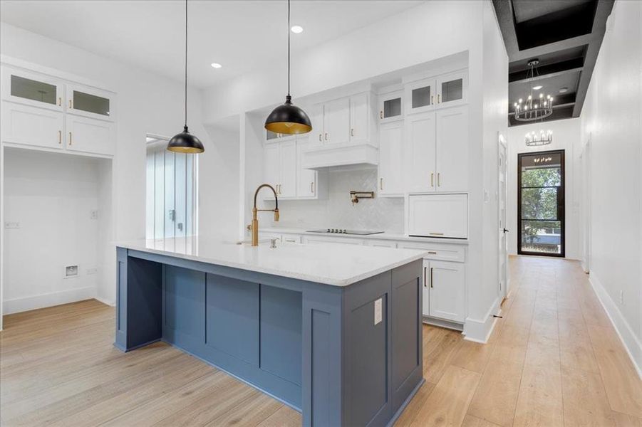 Kitchen featuring glass insert cabinets, white cabinetry, pendant lighting, tasteful backsplash, and recessed lighting