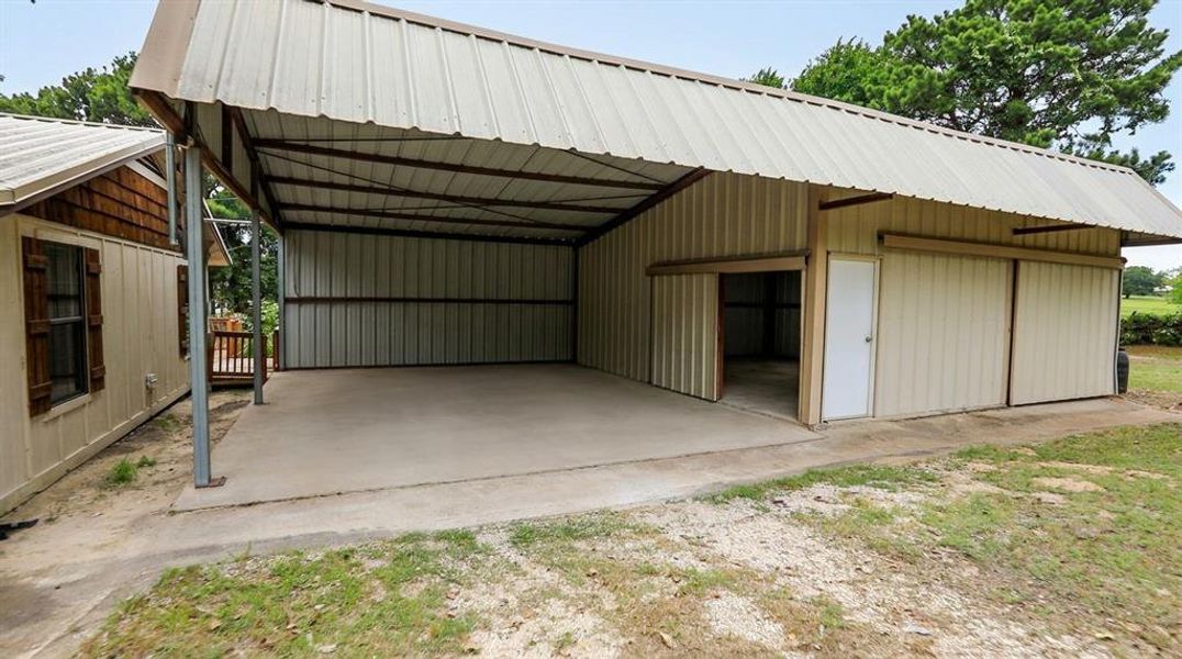 Large metal workshop featuring enclosed storage space and a covered lean-to, ideal for equipment, projects, or additional parking. Large metal workshop featuring enclosed storage space and a covered lean-to, ideal for equipment, projects, or additional parking.