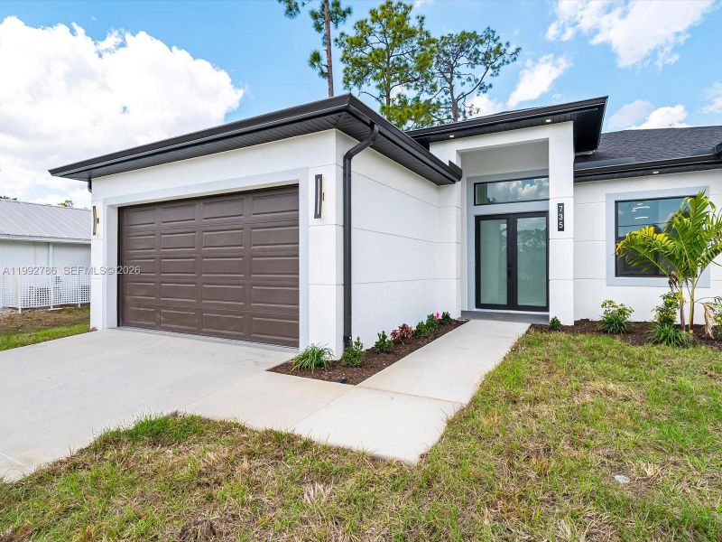 Front exterior of a new home in , Lehigh Acres, FL, highlighting curb appeal (Image 19).