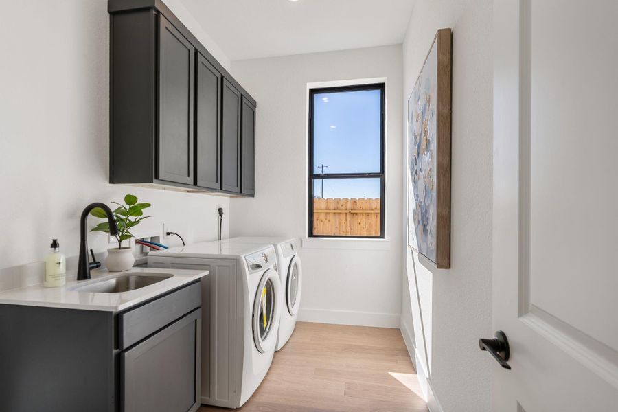 Thoughtful storage and a window providing abundant light make the laundry room practical and well-designed