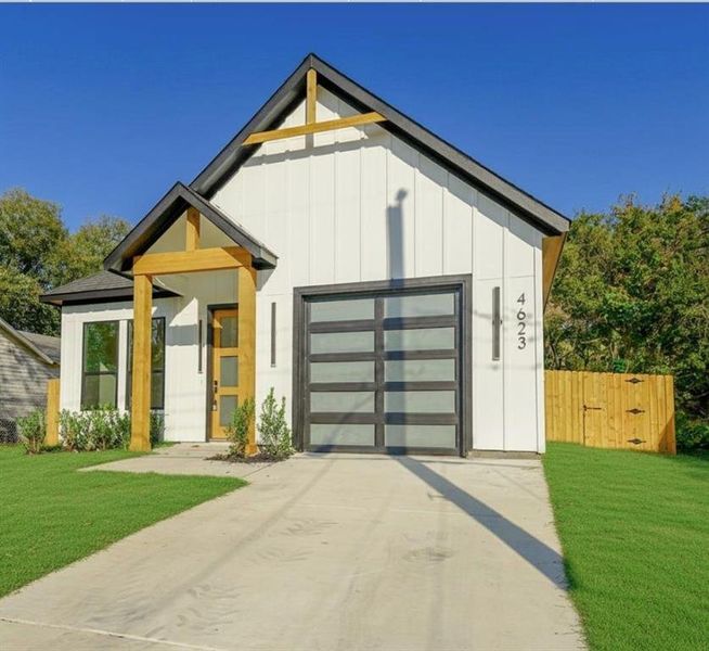 View of front facade featuring concrete driveway, board and batten siding, and an attached garage View of front facade featuring concrete driveway, board and batten siding, and an attached garage