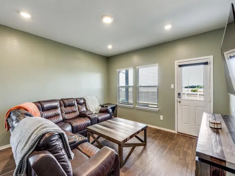 Living area with dark wood-style flooring and recessed lighting