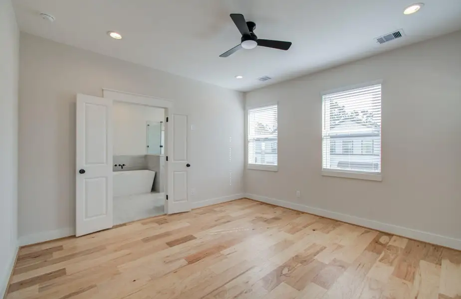 Welcome to your luxurious primary suite, where elegance meets comfort. Bask in the warm glow of natural light pouring through the oversized windows, accentuating the rich wood floors beneath your feet. This serene space is designed for rest and restoration, complete with your own en-suite spa-inspired bathroom—offering the perfect end to every day.