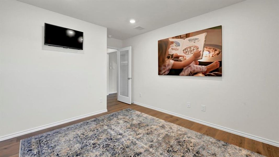 Empty room with dark wood-style flooring and recessed lighting