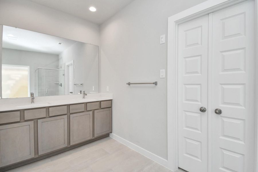 Elevate your daily routine at the elegant vanity, now equipped with double sinks, light countertops, modern hardware, and beautiful recessed lights. Sample photo of completed home with similar floor plan. Actual colors and selections may vary. Elevate your daily routine at the elegant vanity, now equipped with double sinks, light countertops, modern hardware, and beautiful recessed lights. Sample photo of completed home with similar floor plan. Actual colors and selections may vary.