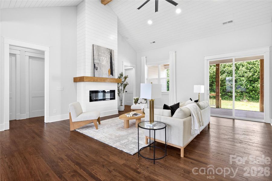 Some living rooms look good in photos but still feel stiff in person. The fireplace, high ceilings, and natural light here make this space feel warm the second you walk in