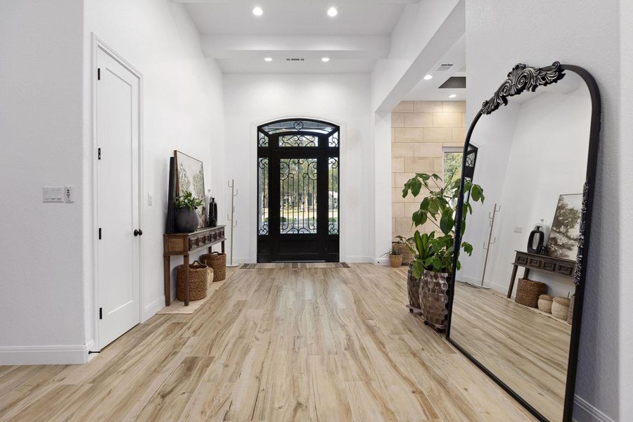 Foyer entrance featuring light wood-type flooring, recessed lighting, and a towering ceiling Foyer entrance featuring light wood-type flooring, recessed lighting, and a towering ceiling