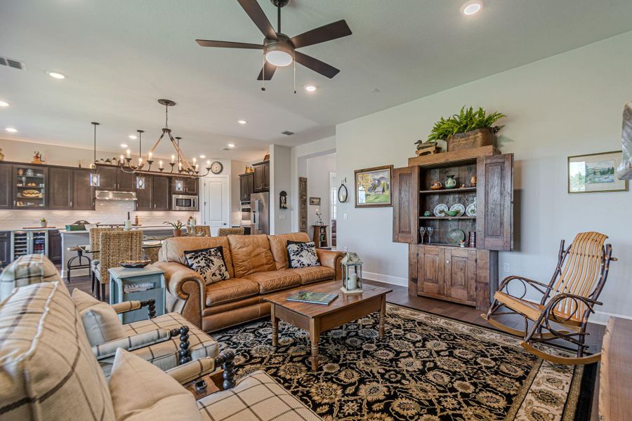 Living room with ceiling fan, recessed lighting, dark wood-style floors, and a chandelier