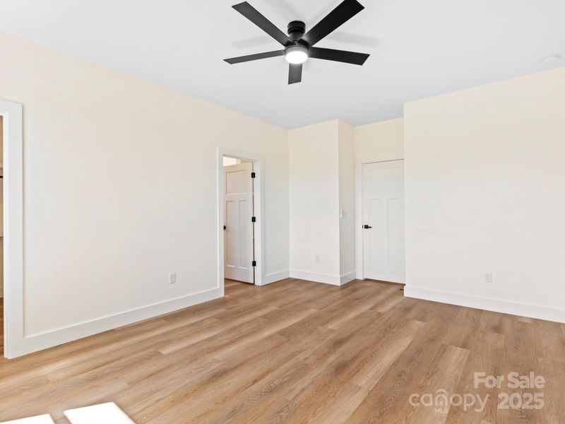 The sun filled primary bedroom sits comfortably at the back of the house. And windows open to a mountain view.