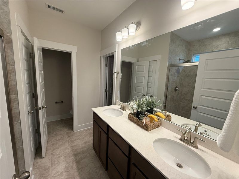 This bathroom features a double vanity and sleek m