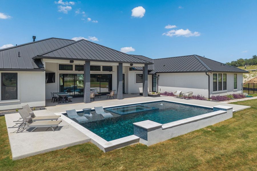 A sparkling geometric pool and covered patio highlight the modern rear exterior of this home.