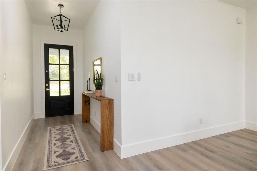 Entrance foyer featuring an inviting chandelier and light wood-type flooring