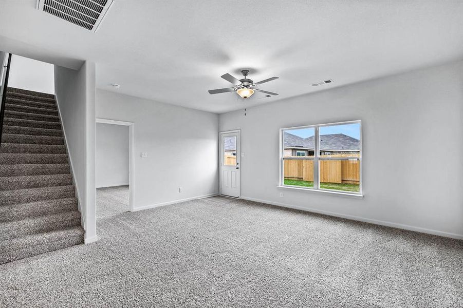 Unfurnished living room featuring carpet floors and ceiling fan