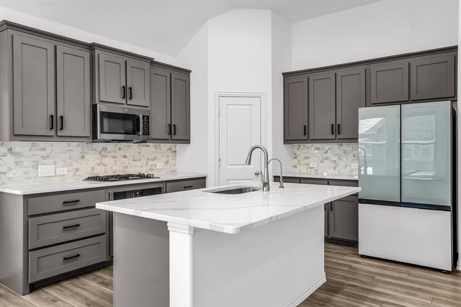 Kitchen featuring a large central island with an undermount sink and gooseneck faucet