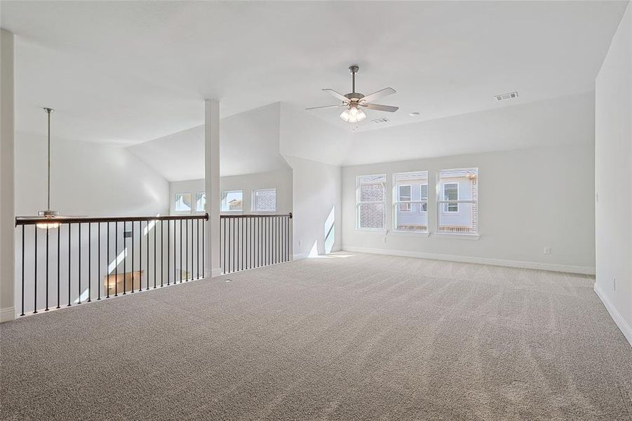 Unfurnished room featuring ceiling fan, carpet floors, and lofted ceiling Unfurnished room featuring ceiling fan, carpet floors, and lofted ceiling