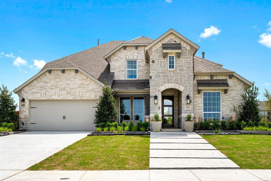 French country home featuring a garage and a front lawn