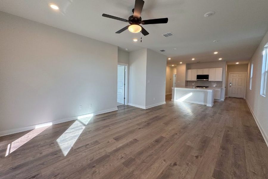 A room with a wood floor and a ceiling fan.