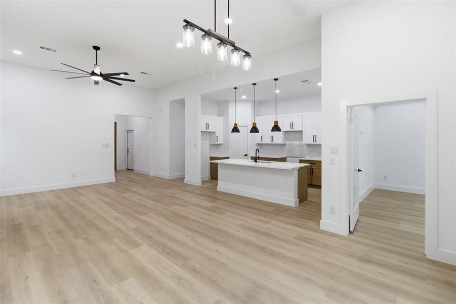 Unfurnished living room featuring light wood finished floors, a ceiling fan, and recessed lighting