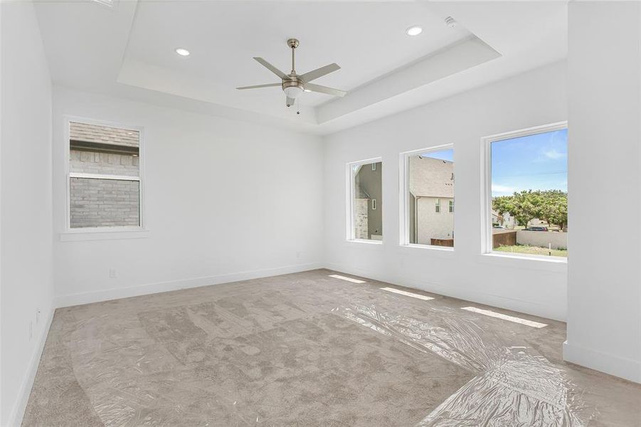 Spare room with ceiling fan and a tray ceiling